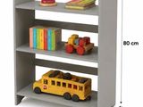 La bibliothèque comporte trois étagères sur lesquelles sont rangés des livres et des jouets.