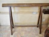a wooden table with a shelf on it in a room