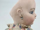 a close up of a doll with a bald head and blue eyes
