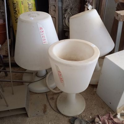 trois vases blancs posés les uns à côté des autres sur le sol