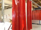many red curtains hanging from the ceiling in a room