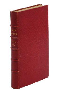un livre rouge posé sur une surface blanche