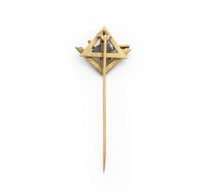une broche en or ornée d'un diamant et d'une croix