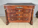 une commode ancienne en bois, ornée de ferrures en laiton sur le dessus