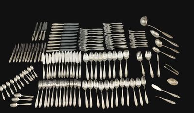 many forks and spoons laid out on the table