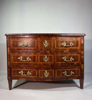 une commode ancienne avec des poignées en laiton et des tiroirs