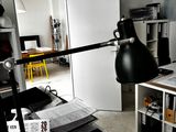un bureau avec une lampe, une chaise, une bibliothèque et d'autres objets dans une pièce