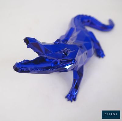 un alligator en plastique bleu posé sur une table