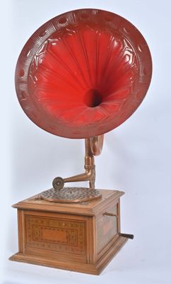un gramophone rouge posé sur une table en bois