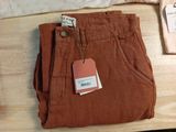 a pair of brown pants sitting on a table next to a pillow
