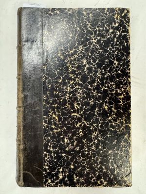 un gros plan d'un livre à la couverture noire posé sur une surface blanche