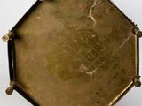 a brass plate with a picture on it on a white surface