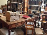 une pièce remplie de livres et de cartons posés par terre