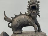 a bronze statue of a lion on top of a metal object