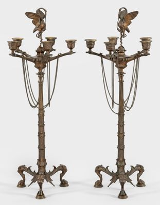 a pair of brass candlesticks with birds on them