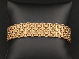 un bracelet en or posé sur un coussin noir