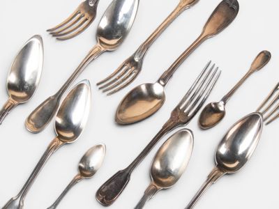 a lot of silver spoons and forks on the table