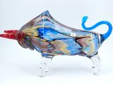brightly colored glass sculpture of a cow with a red horn