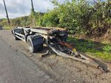 une remorque à plateau qui a été garée sur le bas-côté de la route