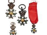 trois médailles et un ruban rouge sur un fond blanc