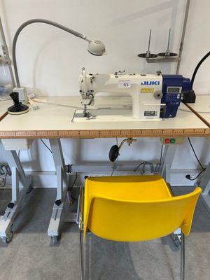 a yellow chair sitting in front of a sewing machine