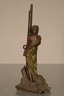 statue en bronze représentant une femme tenant une épée posée sur une table