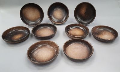 six small brown bowls sitting on top of a white table