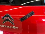a close up of a red car with a sticker on it