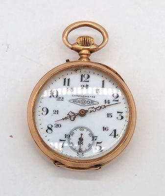 une montre de poche en or avec un cadran blanc sur une surface blanche