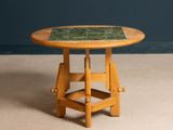 a small wooden table with a tile top on it