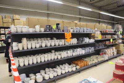 many cups and mugs on the shelves in the store