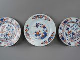trois assiettes bleues et blanches ornées de fleurs orange