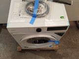 a white washing machine with tape on top of it