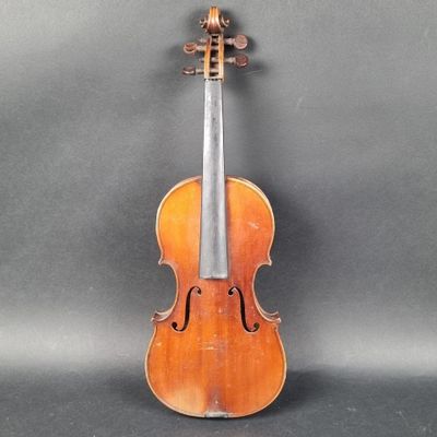 un vieux violon posé sur une table près d'un mur