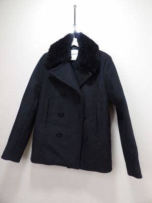 Le manteau est noir et est orné d'un col en fourrure.