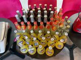 many bottles of soda and orange juice on the table