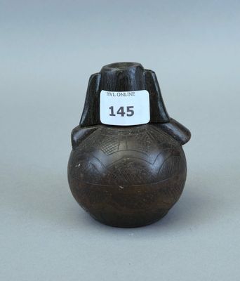un petit vase muni d'une étiquette, posé sur une table