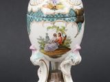 a white and blue vase with a bird on top of it