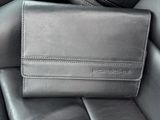 a black leather wallet sitting on top of a car seat