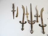 a lot of different types of knives hanging on the wall