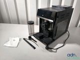 a coffee machine sitting on a table next to a cup of coffee