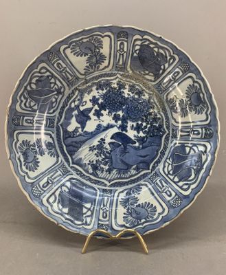 blue and white plate with a design of birds and flowers on it