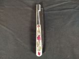 a knife that has been painted with flowers on it
