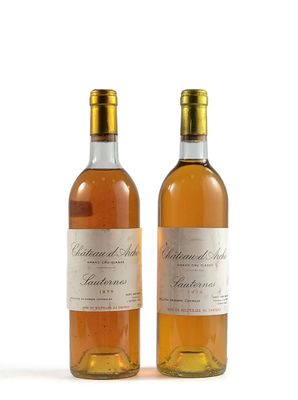 deux bouteilles de vin posées l'une à côté de l'autre sur une surface blanche