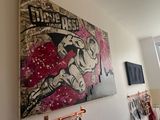 a picture of a painting on the wall above a bed