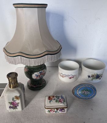 une table sur laquelle se trouvent une lampe, des tasses et d'autres objets