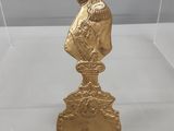 un gros plan sur une statue en or représentant un homme sur un socle
