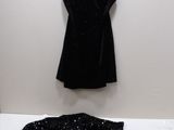 une robe noire suspendue à un cintre à côté d'une veste noire
