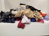 a pile of clothes sitting on top of a white shelf