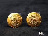 une paire de boucles d'oreilles plaquées or sur fond noir